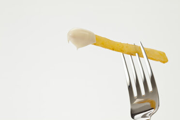 French fries on fork with mayonnaise, close up - CSF016684