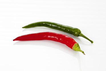 Green and red chili peppers on white background, close up - CSF016695