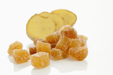 Sliced ginger and pieces of candied ginger on white background, close up - CSF016757