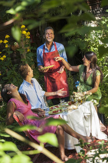 Österreich, Salzburger Land, Mann bedient seine Familie im Garten - HHF004426