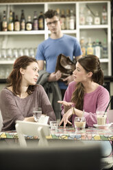 Deutschland, Bayern, München, Frauen warten im Cafe, während ein Freund ankommt - RNF001135