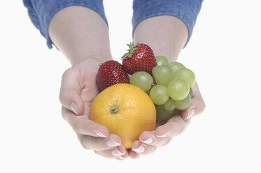 Human hands holding fruits against white background, close up - CRF002295