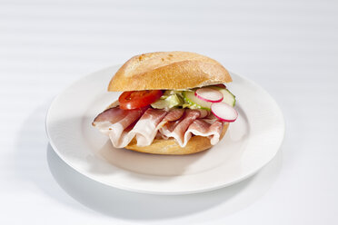 Sandwich of bread roll with black forest ham on plate, close up - CSF017242