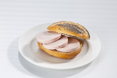 Sandwich aus Mohnbrötchen mit Schinkenwurst auf einem Teller, Nahaufnahme - CSF017249
