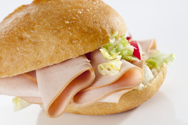 Brötchensandwich mit Mortadella auf weißem Hintergrund, Nahaufnahme - CSF017264