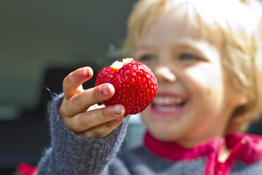 Girl holding strawberry in her hand, close up - JFEF000006