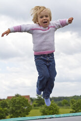 Germany, Kiel, Girl jumping on trampoline - JFEF000015