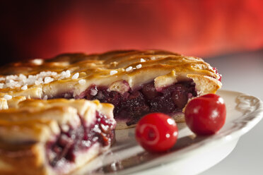 Gittertorte mit Kirschen und Zuckerkristallen auf einem Teller, Nahaufnahme - CSF017365