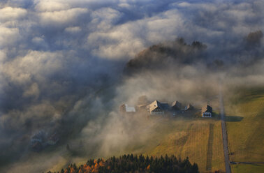 Österreich, Salzkammergut, Blick auf nebelverhangenes Bauernhaus - WW002701