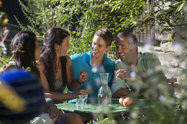 Österreich, Salzburg, Familie plaudert im Garten, lächelnd - HHF004520