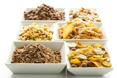 Variety of cereals in bowl on white background, close up - MAEF005975