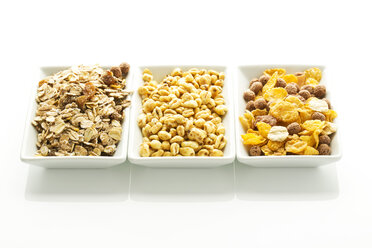 Bowls of variety cereals on white background, close up - MAEF005980