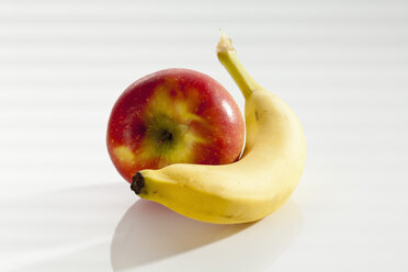 Banana with apple on white background, close up - CSF017515