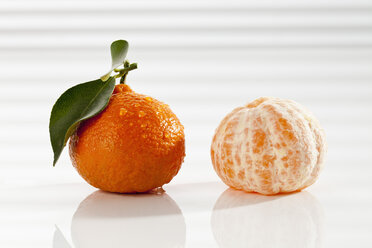 Ganze und geschälte Mandarinen mit Blatt, Nahaufnahme - CSF017500
