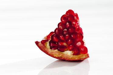 Piece of pomegranate on white background, close up - CSF017480