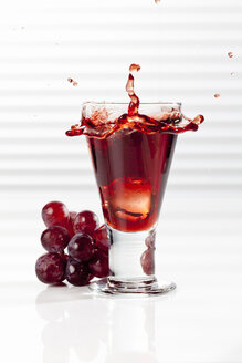 Glas mit spritzendem roten Traubensaft, Nahaufnahme - CSF017427