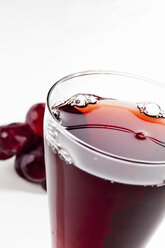 Glass of red grape juice against white background, close up - CSF017425