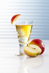 Glass with apple juice and halved apples - CSF017418