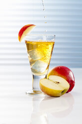 Glass with apple juice and halved apples - CSF017417