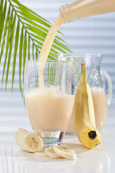 Karaffe und Glas mit einfließendem Bananensaft, Nahaufnahme - CSF017405