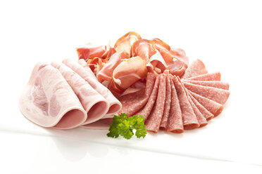 Schweinswürstchen, Speck und Salami auf weißem Hintergrund, Nahaufnahme - MAEF006021