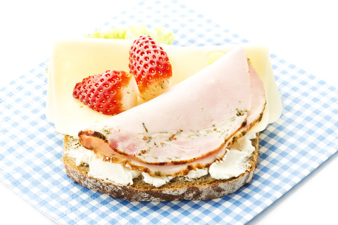 Fitness-Sandwich mit Frischkäse, Käse und Scheibe Schinken und Erdbeere auf weißem Hintergrund, Nahaufnahme, lizenzfreies Stockfoto