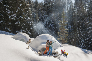 Österreich, Salzburg, Pärchen vor einem Iglu - HHF004540