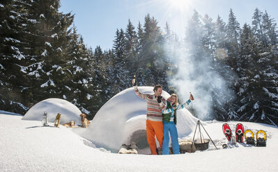 Österreich, Salzburg, Paar hat Spaß vor einem Iglu - HHF004541