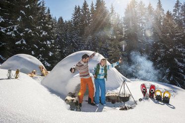 Austria, Salzburg, Couple having fun in front of an igloo - HHF004542