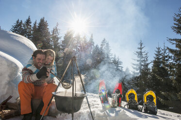 Austria, Salzburg, Couple preparing tea near igloo - HHF004525