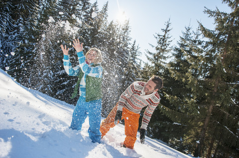 Österreich, Salzburg, Pärchen hat Spaß im Schnee, lächelnd, lizenzfreies Stockfoto