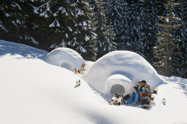 Austria, Salzburg, Couple preparing tea near igloo - HHF004547