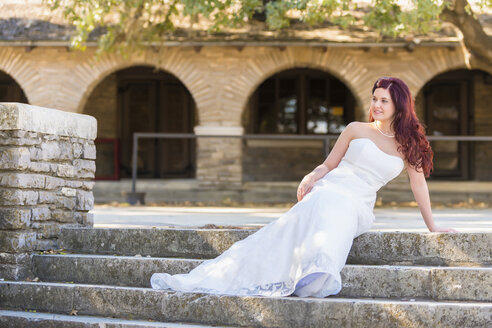 USA, Texas, Junge Braut im Hochzeitskleid posiert vor historischem Gebäude - ABAF000771