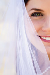 USA, Texas, Junge Braut im Hochzeitskleid posiert lächelnd am Fluss Frio - ABAF000775