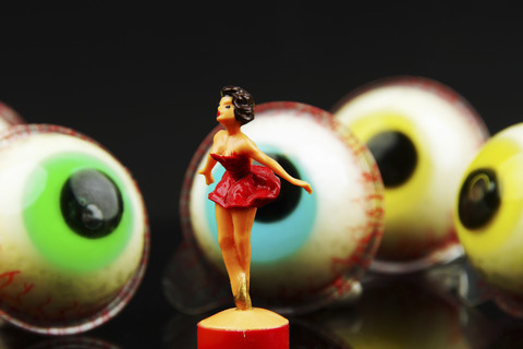 Tanzende Figur in Gießerei Situation mit Süßigkeiten Augäpfel im Hintergrund, lizenzfreies Stockfoto