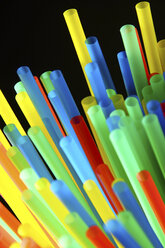 Assortment of colorful drinking straws on black background - HOHF000073
