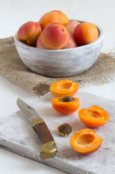 Cross section apricots with knife and bowl of apricots in background - SBDF000001