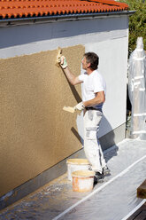 Europe, Germany, Rhineland Palatinate, Man plastering house wall - CSF017694