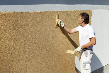 Europe, Germany, Rhineland Palatinate, Man plastering house wall - CSF017666