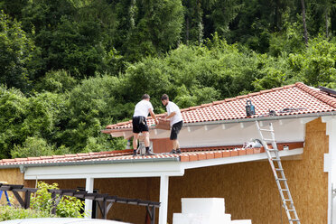 Europa, Deutschland, Rheinland-Pfalz, Männer überdachen Carport mit Ziegeln - CSF017673