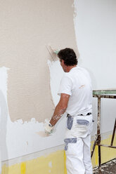 Europe, Germany, Rhineland Palatinate, Man plastering house wall - CSF017675
