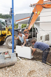 Europe, Germany, Rhineland Palatinate, Men working with corner stones during house building - CSF017685