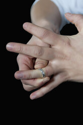 Junge Frau zieht Ring von ihrem Finger, Nahaufnahme - BFRF000192