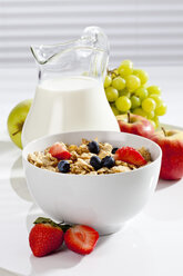 Bowl of cornflakes with various fruits and milk, close up - CSF017627