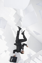 Businessman with briefcase lying down staircase - PDYF000443
