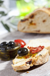 Brotscheibe mit Oliven und getrockneten Tomaten, Nahaufnahme - CSF017745