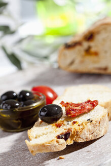 Brotscheibe mit Oliven und getrockneten Tomaten, Nahaufnahme - CSF017748