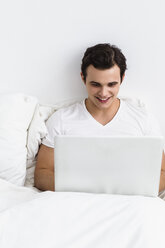 Young man using laptop, smiling - SPOF000068