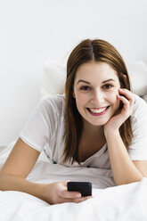 Portrait of young woman using mobile phone, smiling - SPOF000076