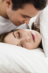 Junger Mann schaut junge Frau im Schlaf an - SPOF000078